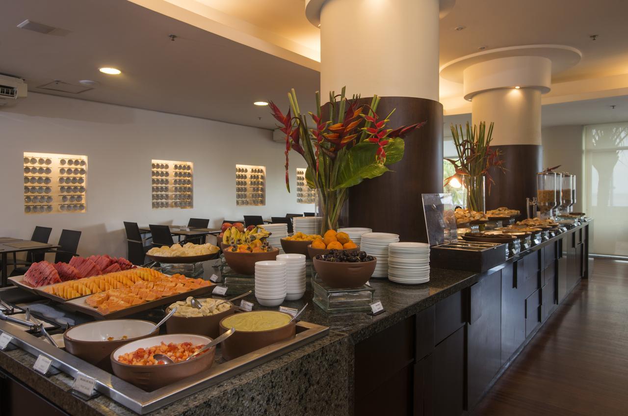 Hotel Luzeiros Fortaleza Exterior foto The photo displays a buffet setup in a dining area. On the counter, there are various dishes arranged attractively. You can see a colorful assortment of fruits and salads, including slices of watermelon and other fruits. There are also several bowls 